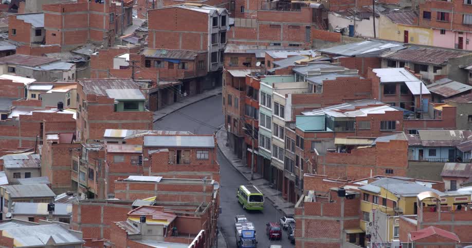 Vehicles drive down the small road in the city