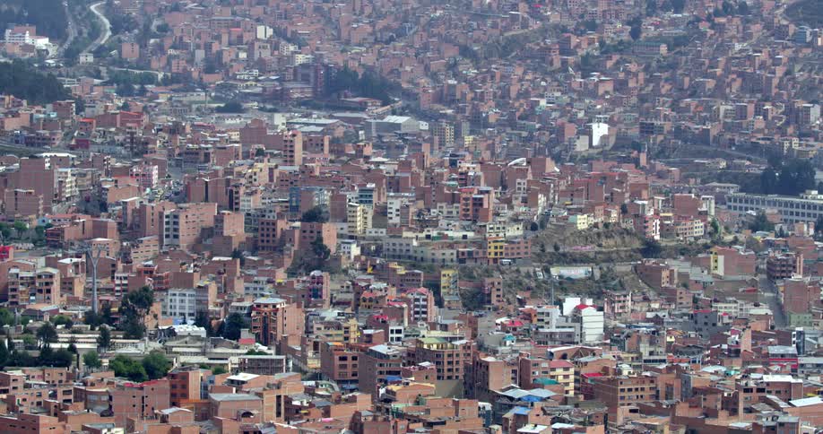 Aerial view of homes and cars driving through neighborhoods in a city