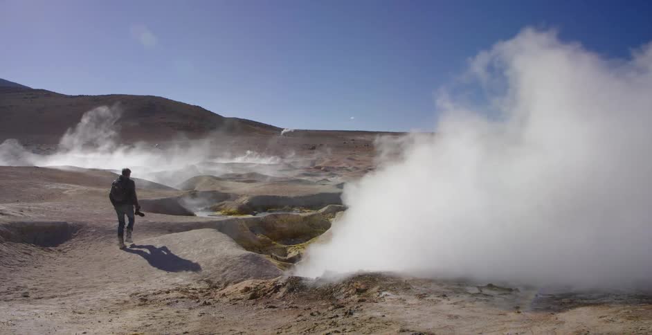 A man stops to take a picture of the rising smoke