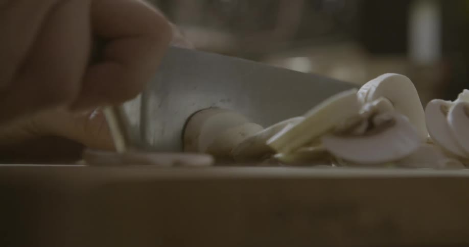 A person is chopping mushrooms with a knife