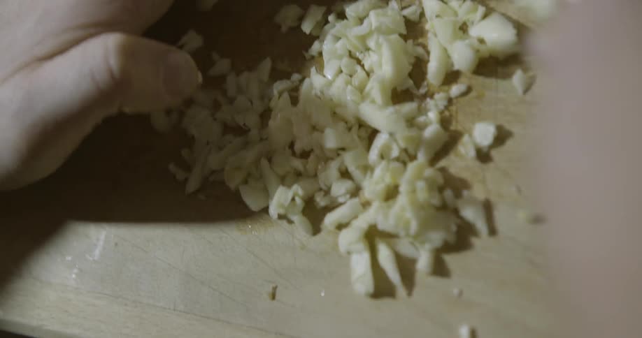 A person is dicing up something on a board