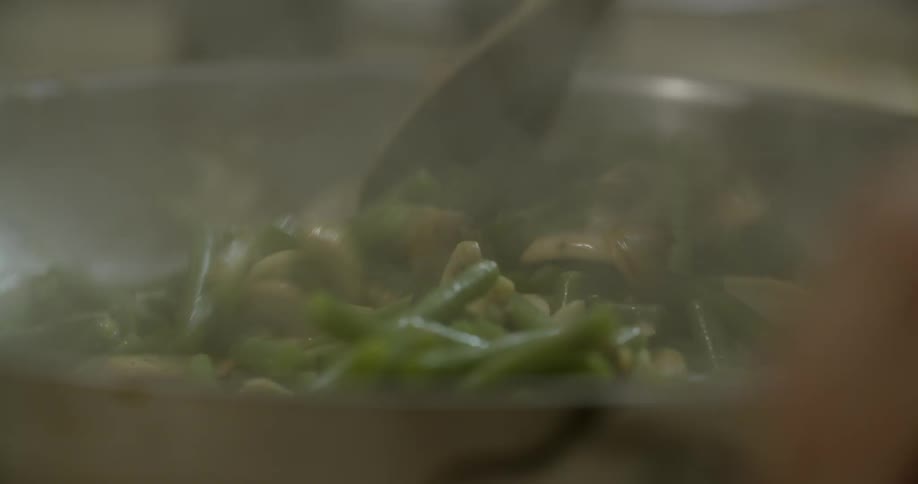A person stirs food in a pan