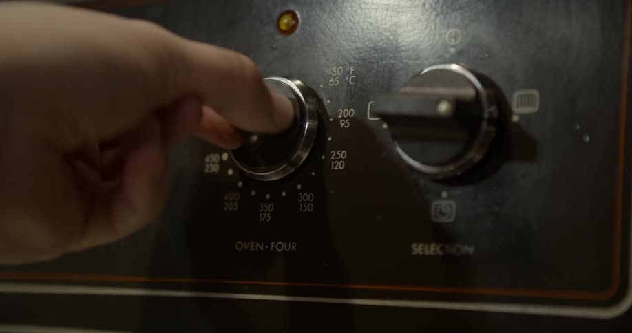 A person turns on an oven