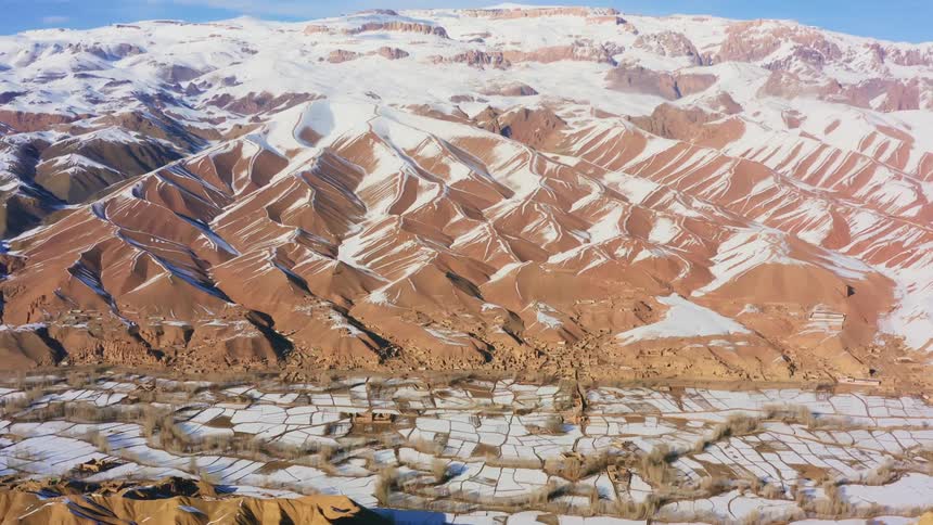Snow on some rocky mountains above the desert floor