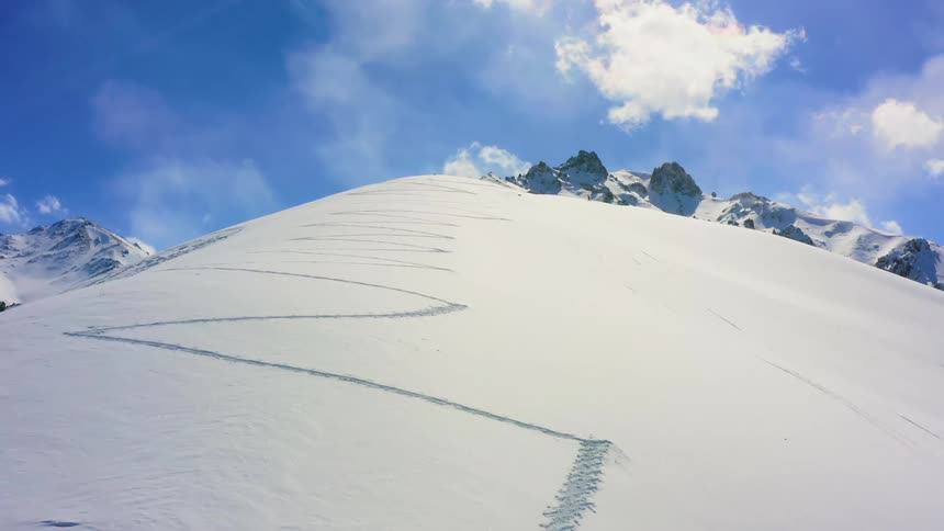 Revealing snow covered mountains behind a hill