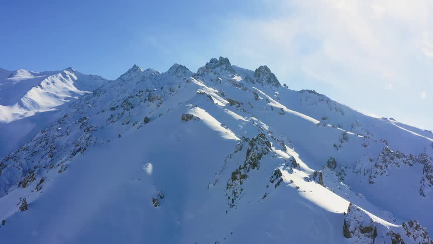 A snow covered mountain ridge on a sunny day
