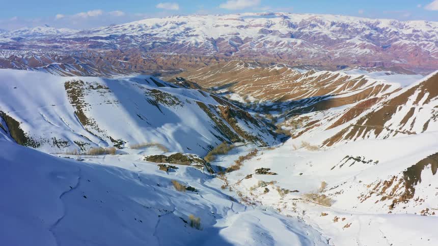 A snow covered mountain valley on a sunny day