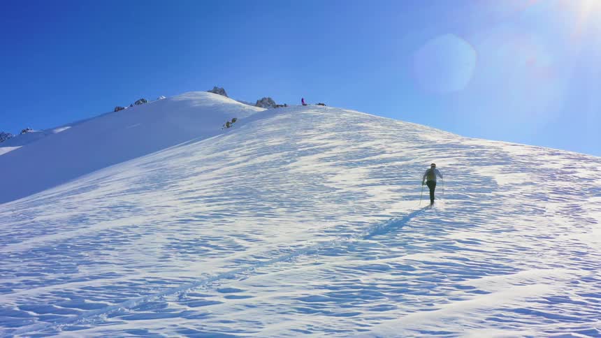 A person is walking through the snow in an arctic area