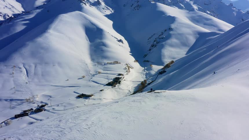 An aerial view of a snow covered mountain is displayed