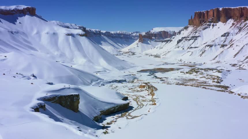 Snow and water fill a mountain valley