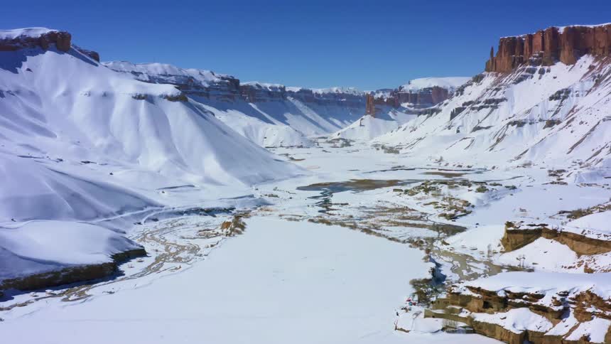 An aerial view of a snowy mountain is displayed