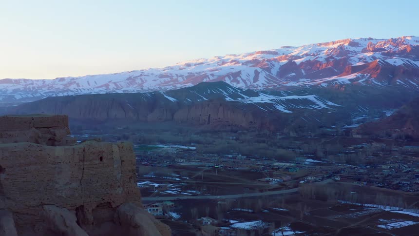 Aerial view of snow covered mountain with a small town below