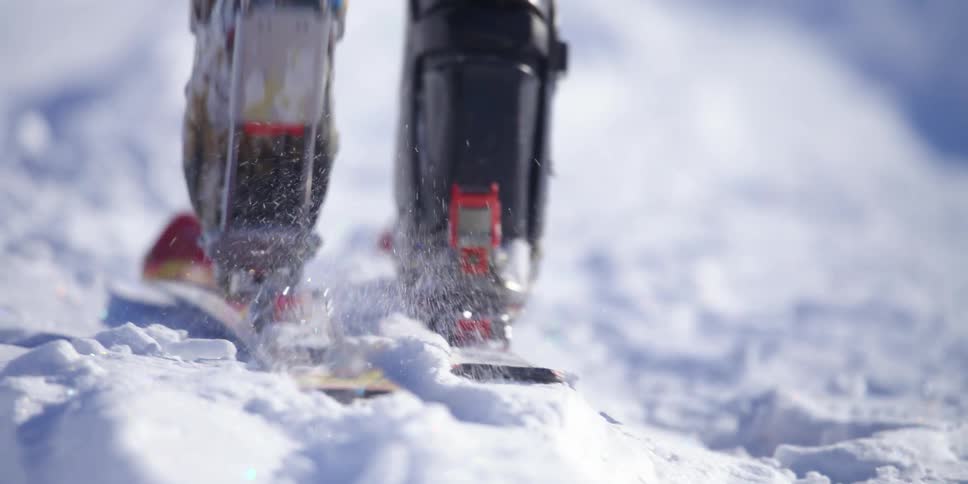 A person hikes across a field of snow on a pair of skis
