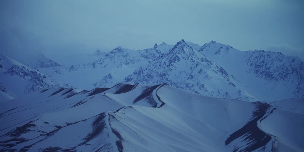 Snow capped mountain range on a foggy day