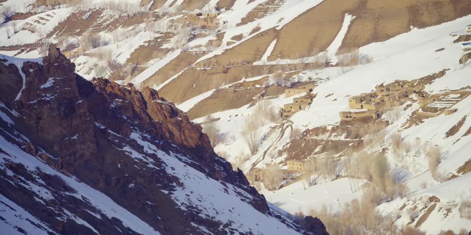 An aerial view of a mountain is displayed in winter