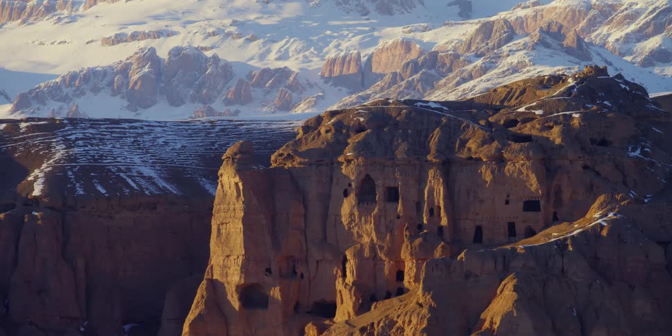 The side of the mountain has shelters carved into the side