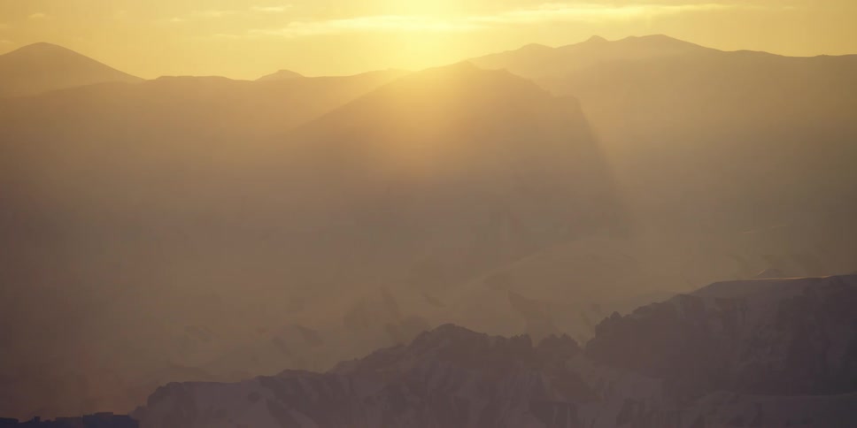 An aerial view of mountains at dusk is displayed