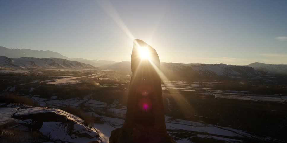 The sun shining down on a large rock formation