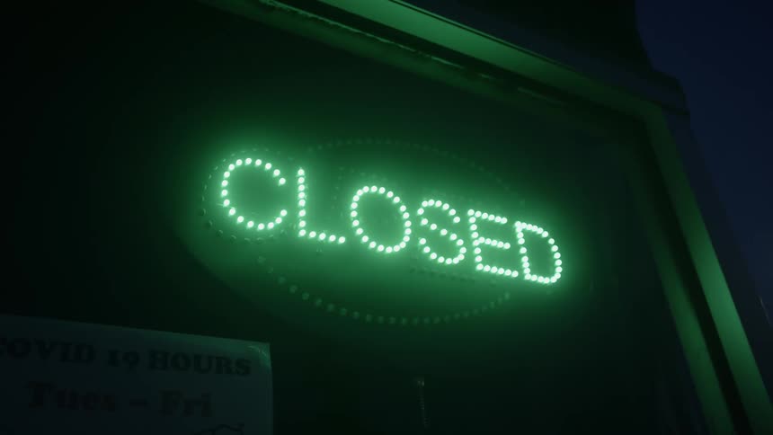 A neon closed sign on a store