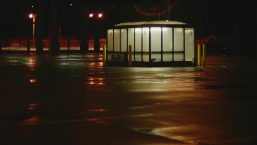 A train pulls past the booth in the empty parking lot