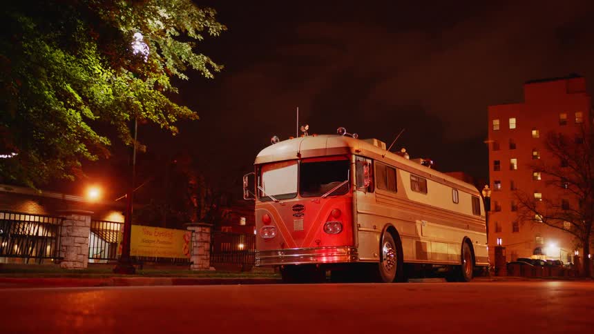 Vintage bus parked on the street of a small city at night