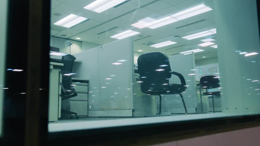 Empty desks on the cubicles of an office at night