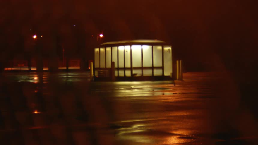 The booth in the parking lot is lit at night