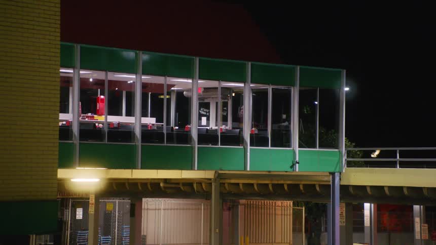A car drives past the building at night