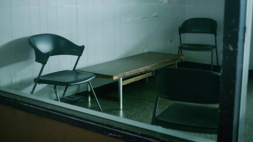 Three folding chairs sit near a wooden table in a room