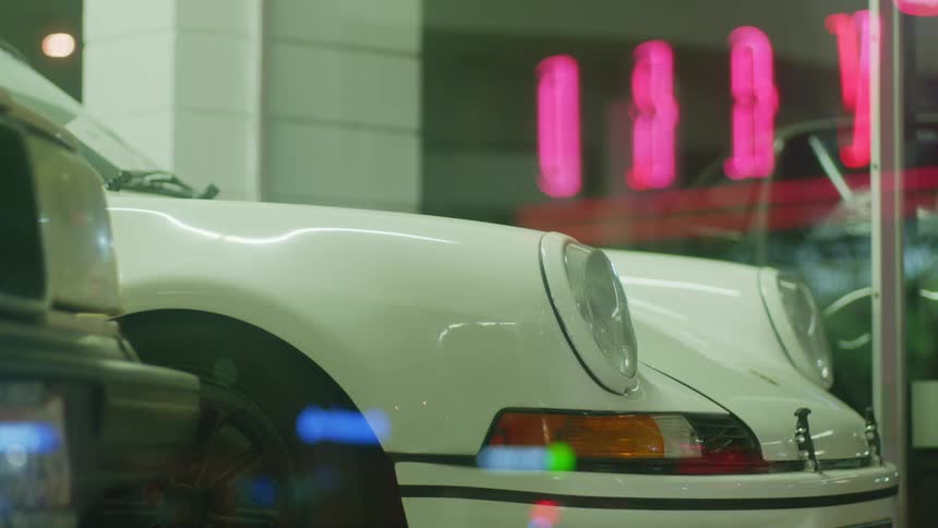 A white car sits inside an auto dealership
