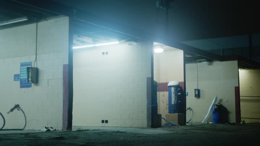 Fluorescent lights of a small town car wash building at night