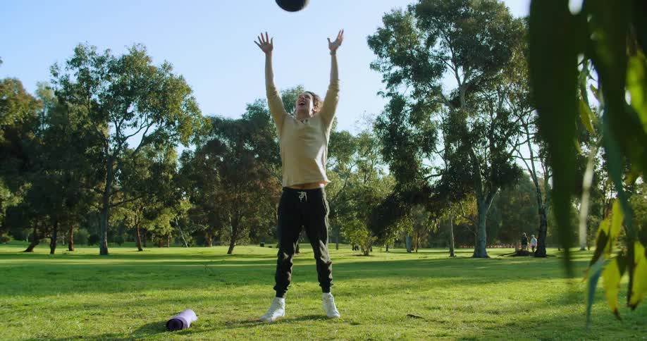 A man tosses a medicine ball up in the air