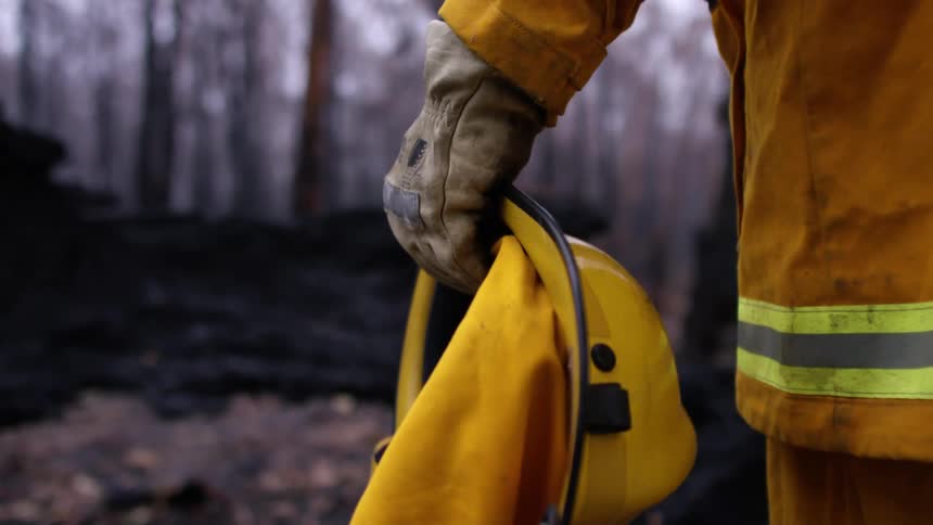 A firefighter takes off his helmet
