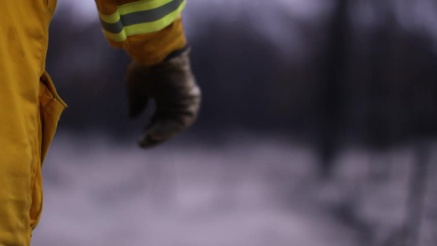 A firefighter is walking over the field