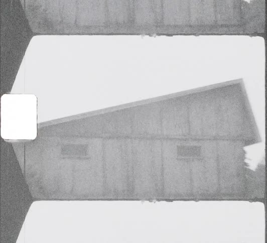 The exterior of an old building with a sloped roof during the day