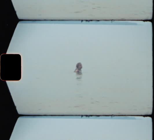 A person swimming in water with the sky and clouds in the background