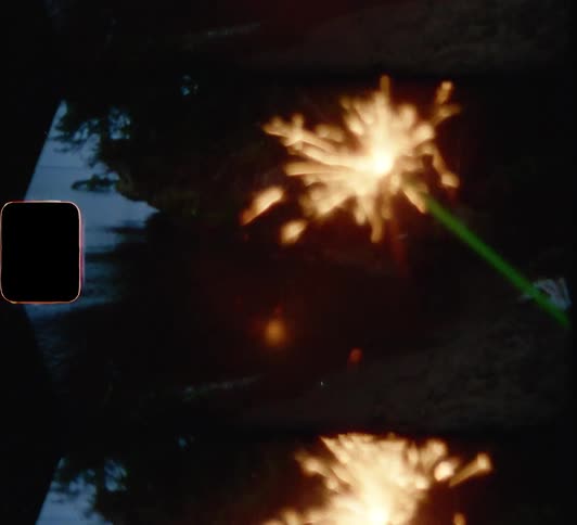 A person is waving a sparkler on the field