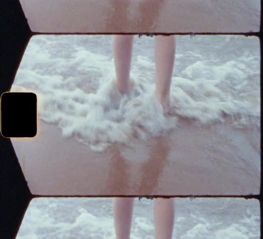 A person on the beach jumping on waves and splashing water on the sand