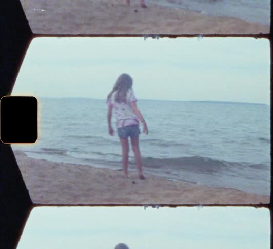 Vintage footage of sisters playing on the shoreline on the coast