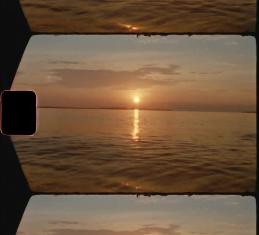 The sun sets over the calm sea