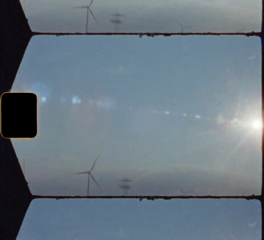 Wind turbines in field from moving vehicle 8mm