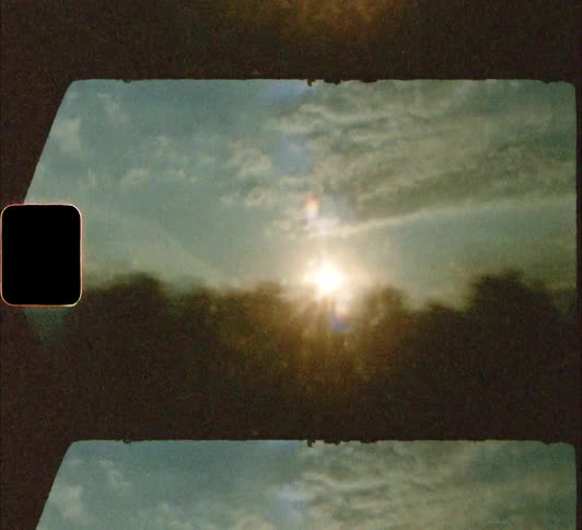 View out of moving vehicle towards sun and trees 8mm
