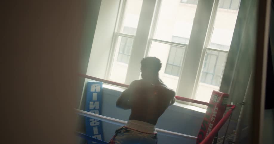 A man jabs in a boxing ring by himself