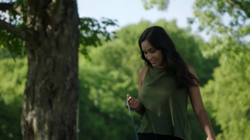 A woman is walking her dog outdoors in spring