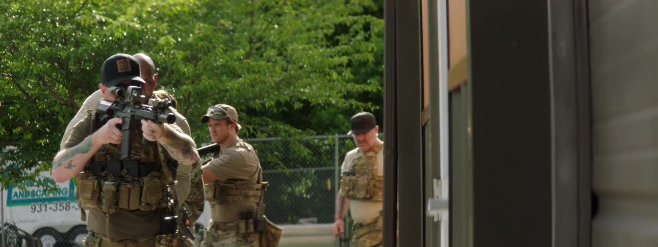 Civilian militia running training exercise outside building