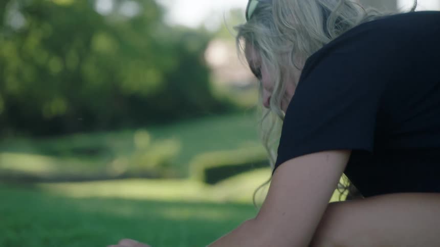 A woman is petting her dog outdoors in spring