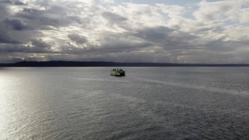 Aerial view of a ferry boat traveling across the sea on a cloudy day