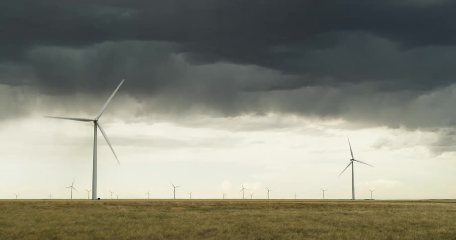 Wind turbines rotate in a wind farm on a cloudy day