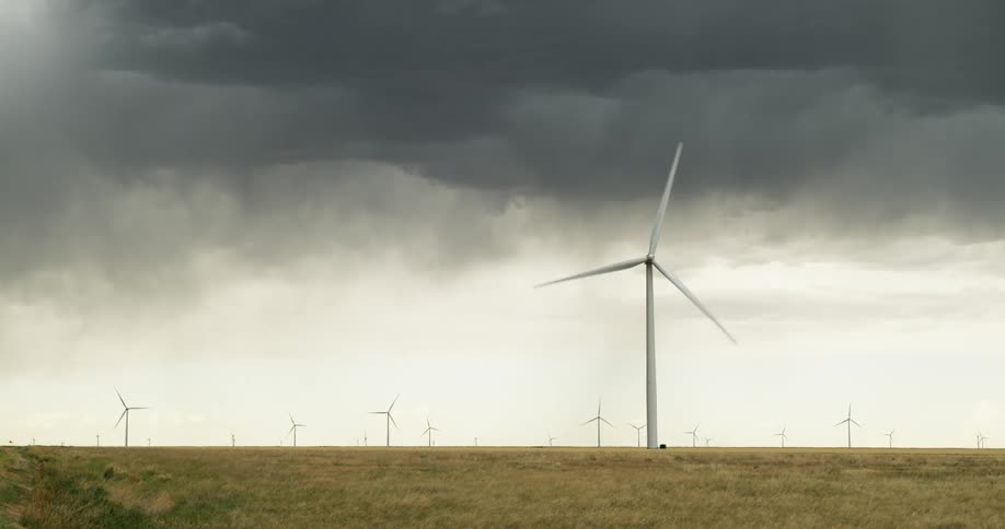Wind turbines rotate in a wind farm on a cloudy day