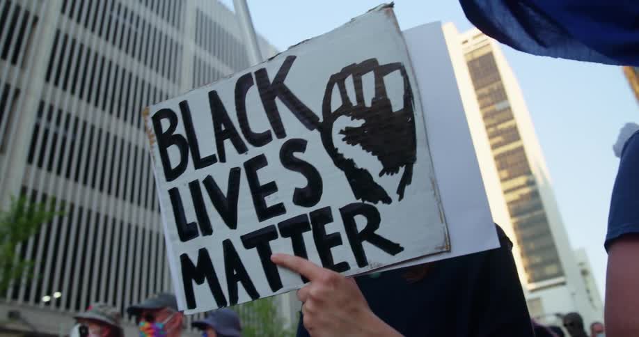 A group of people hold signs and take pictures at a protest